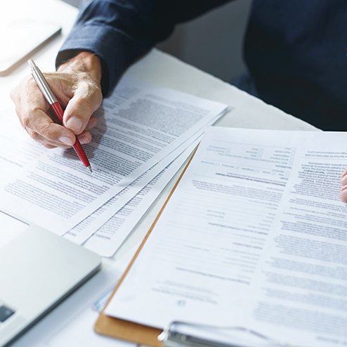 Person sitting at desk, working on insurance documents